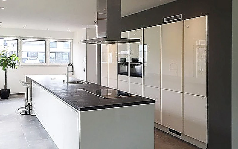 Offene Wohnküche mit zentraler Kochinsel, integriertem Kochfeld und modernen Hochschränken.